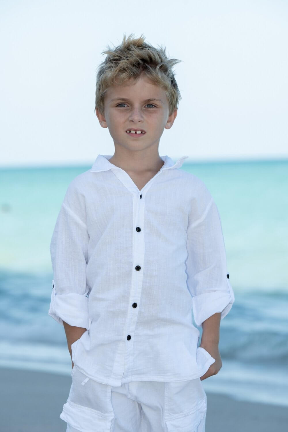 Boy on beach with white top